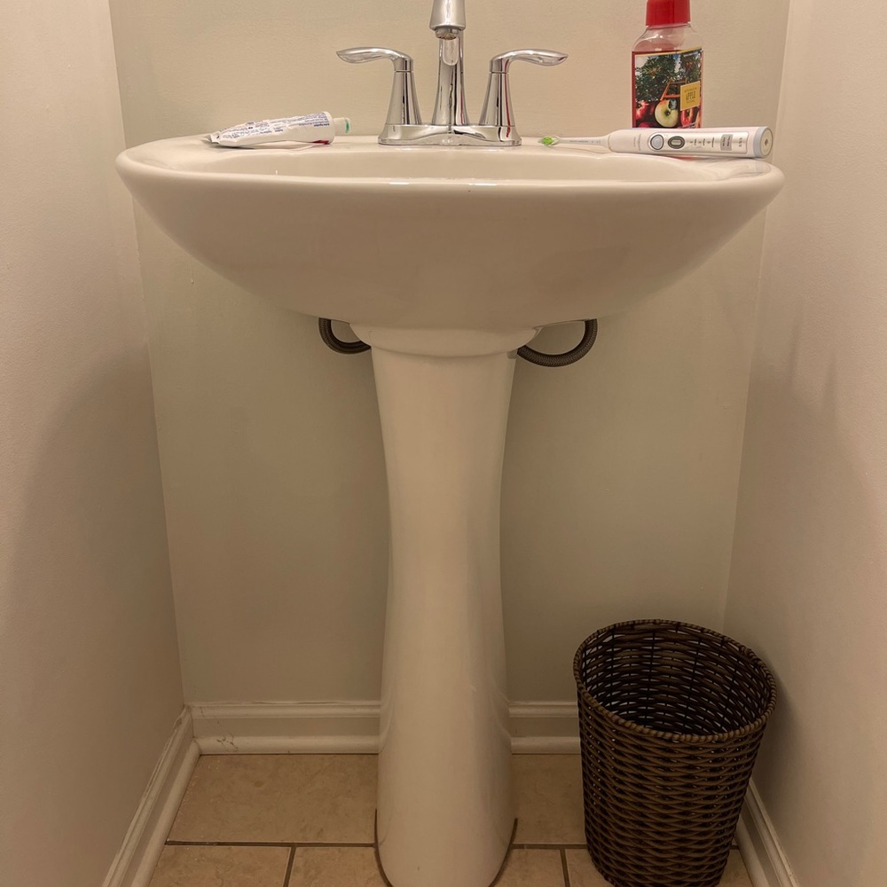 White pedestal sink with faucet